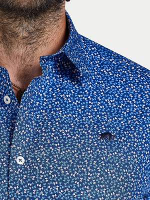 Close-up of a person wearing a blue patterned shirt with a blurred background