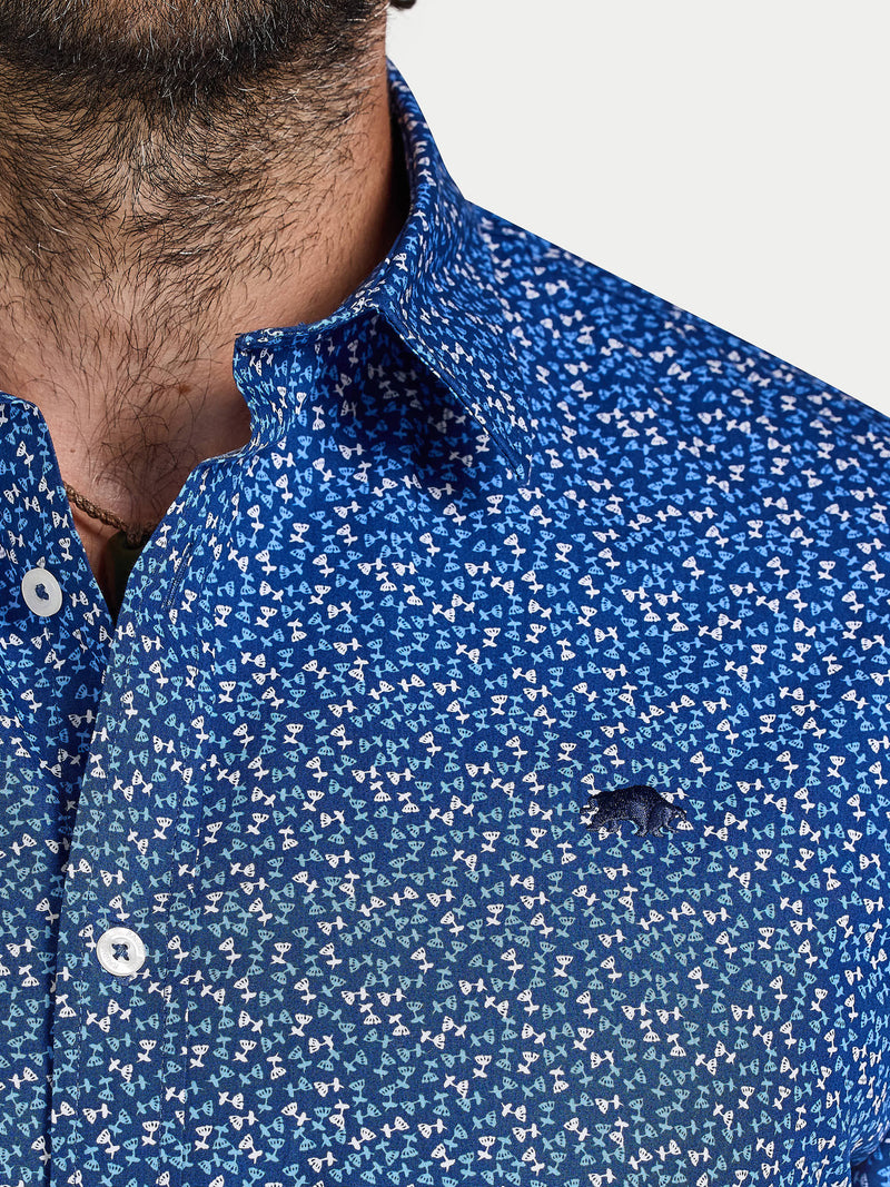 Close-up of a person wearing a blue patterned shirt with a blurred background