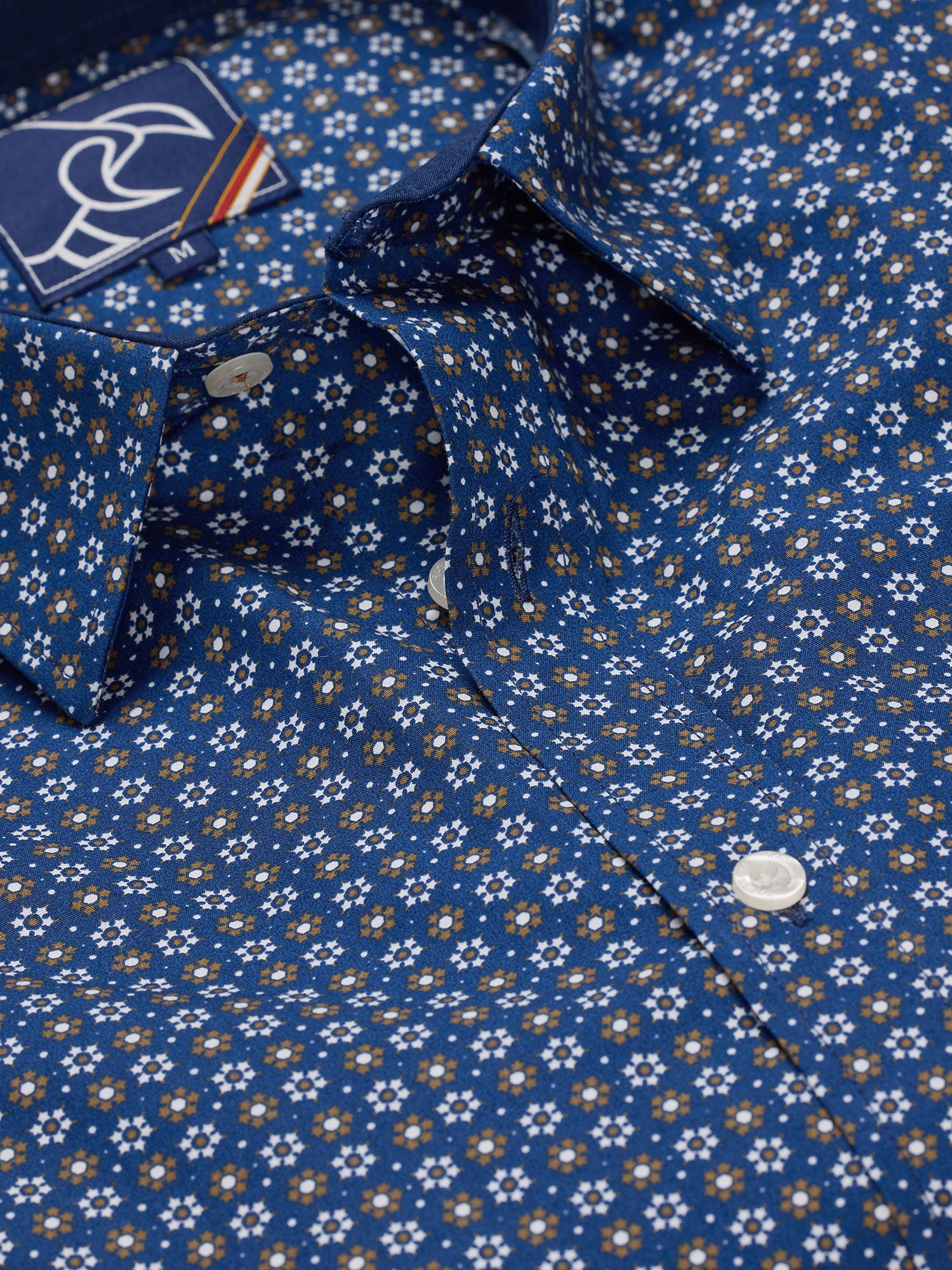 A navy-colored, long sleeve, button-up shirt with a geometric pattern, displayed in a folded state.