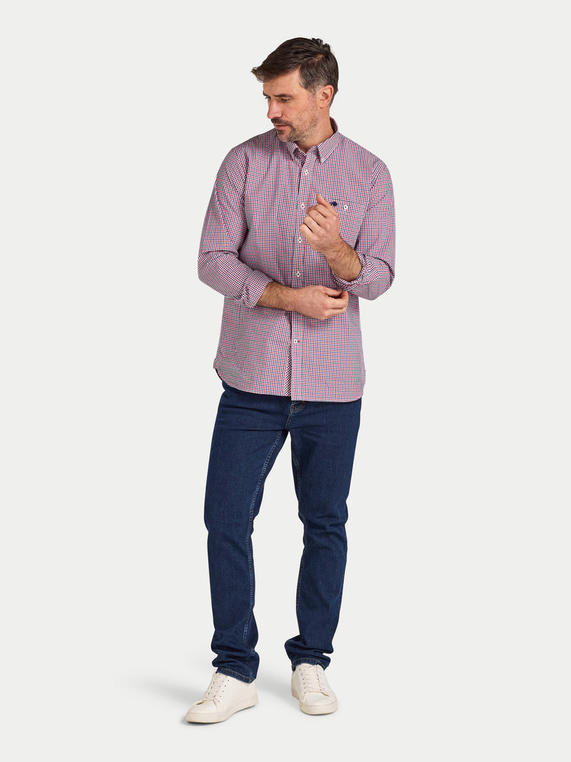 Man wearing a purple checkered shirt and blue jeans on a white background