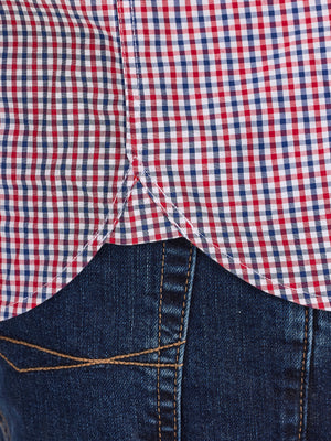 Close-up of a red, white, and blue checkered shirt over a dark denim jacket.