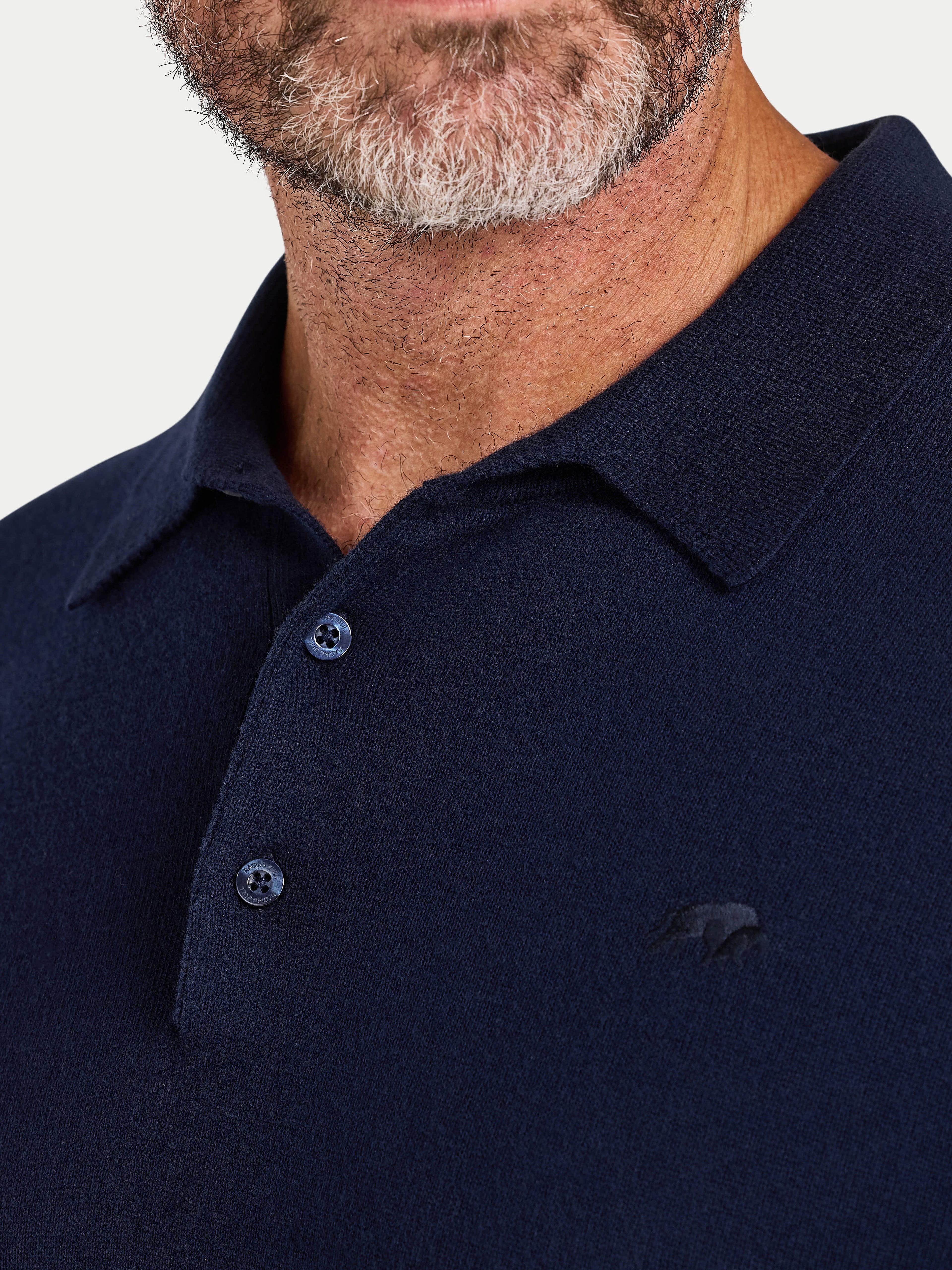 Navy blue polo shirt with a brand logo on a light gray background