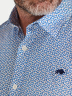 Close-up of a person wearing a blue patterned shirt with a small Raging Bull logo.