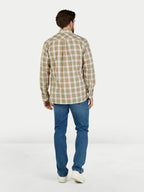 Man wearing a plaid shirt and blue jeans on a white background