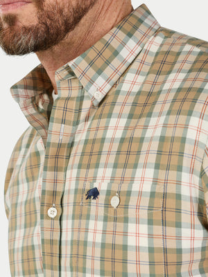 Close-up of a man wearing a plaid shirt with a visible brand logo.