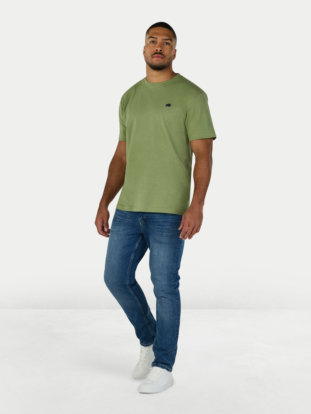Man wearing a green t-shirt and blue jeans on a white background