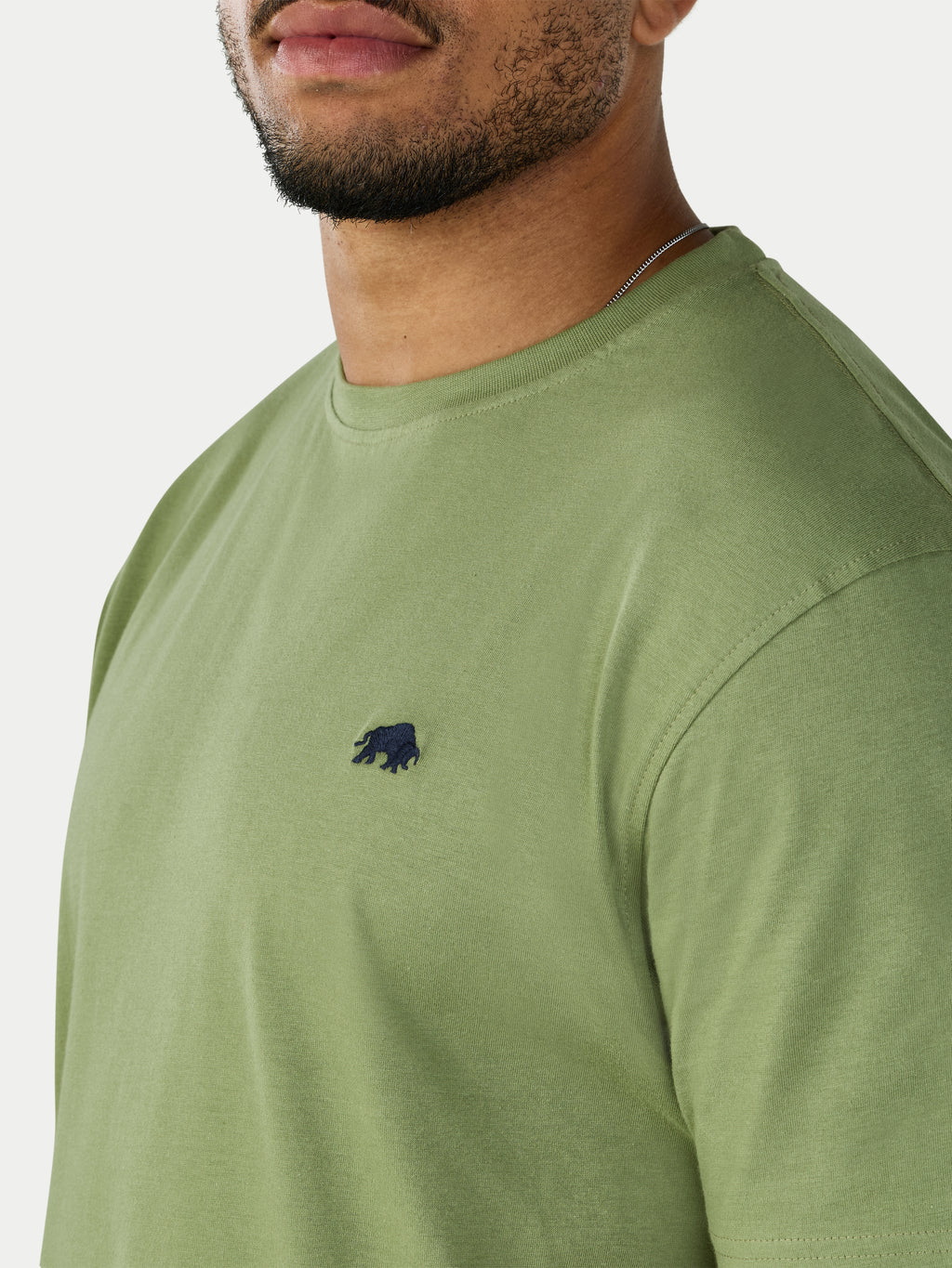 Green t-shirt with a small black logo on a white background