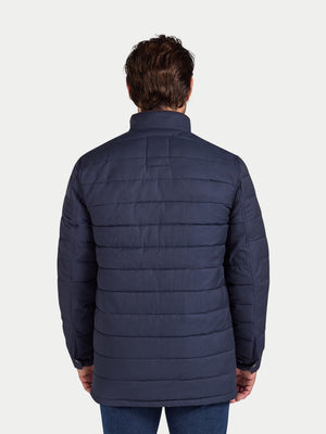 Man wearing a navy blue puffer jacket on a white background
