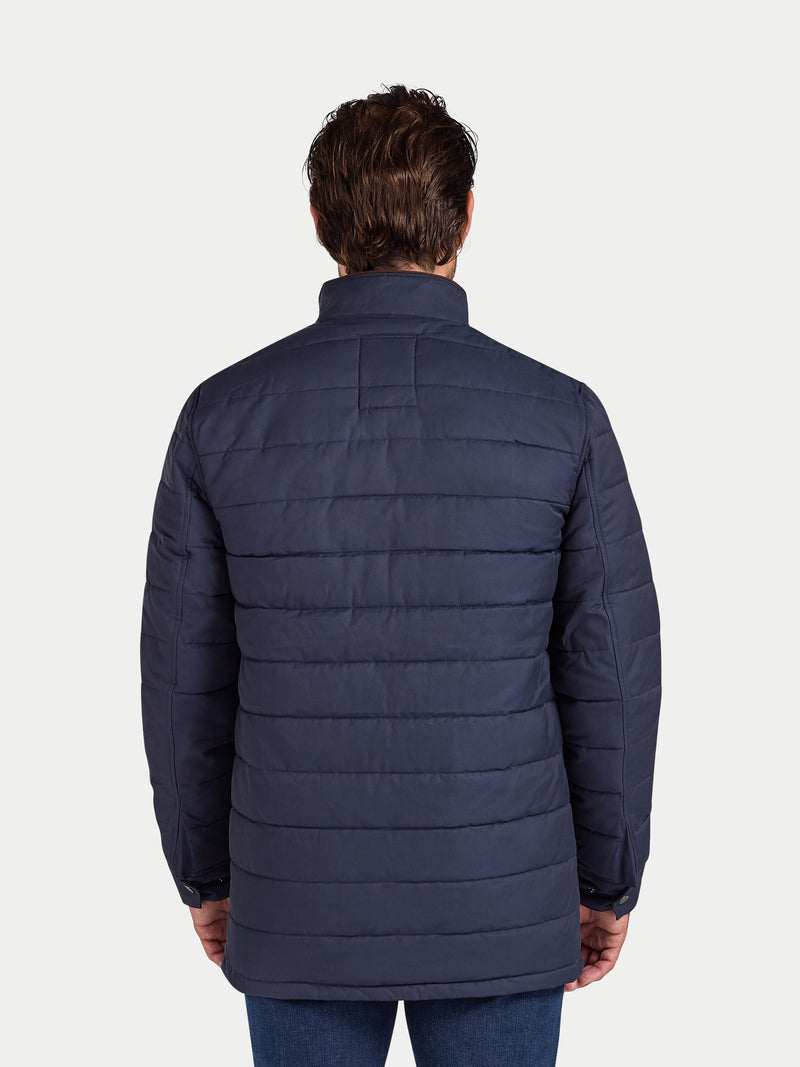 Man wearing a navy blue puffer jacket on a white background