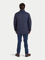 Man wearing a blue puffer jacket and jeans on a white background
