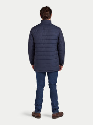 Man wearing a blue puffer jacket and jeans on a white background
