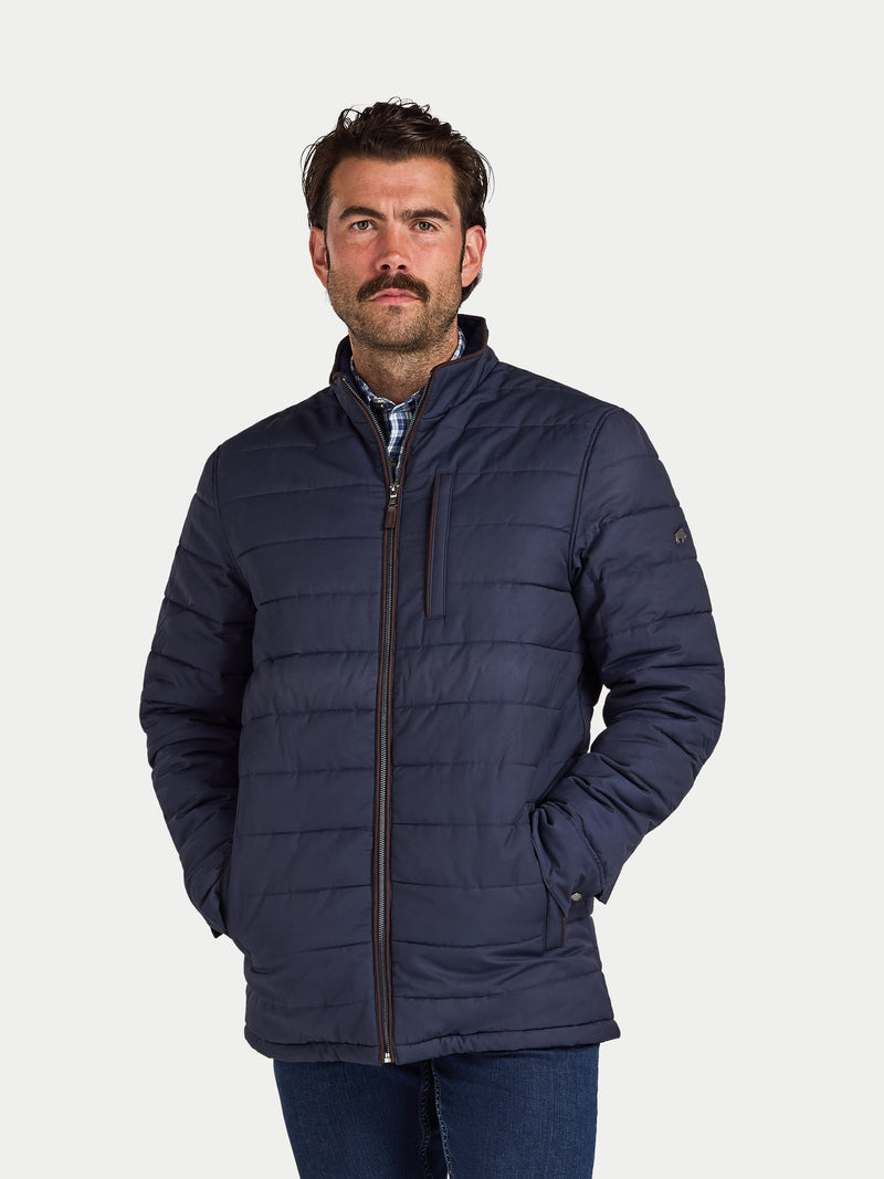 Man wearing a navy blue puffer jacket on a white background