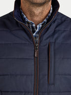 Navy puffer jacket with a plaid shirt underneath on a white background