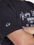 Person wearing a black t-shirt with white text and logo