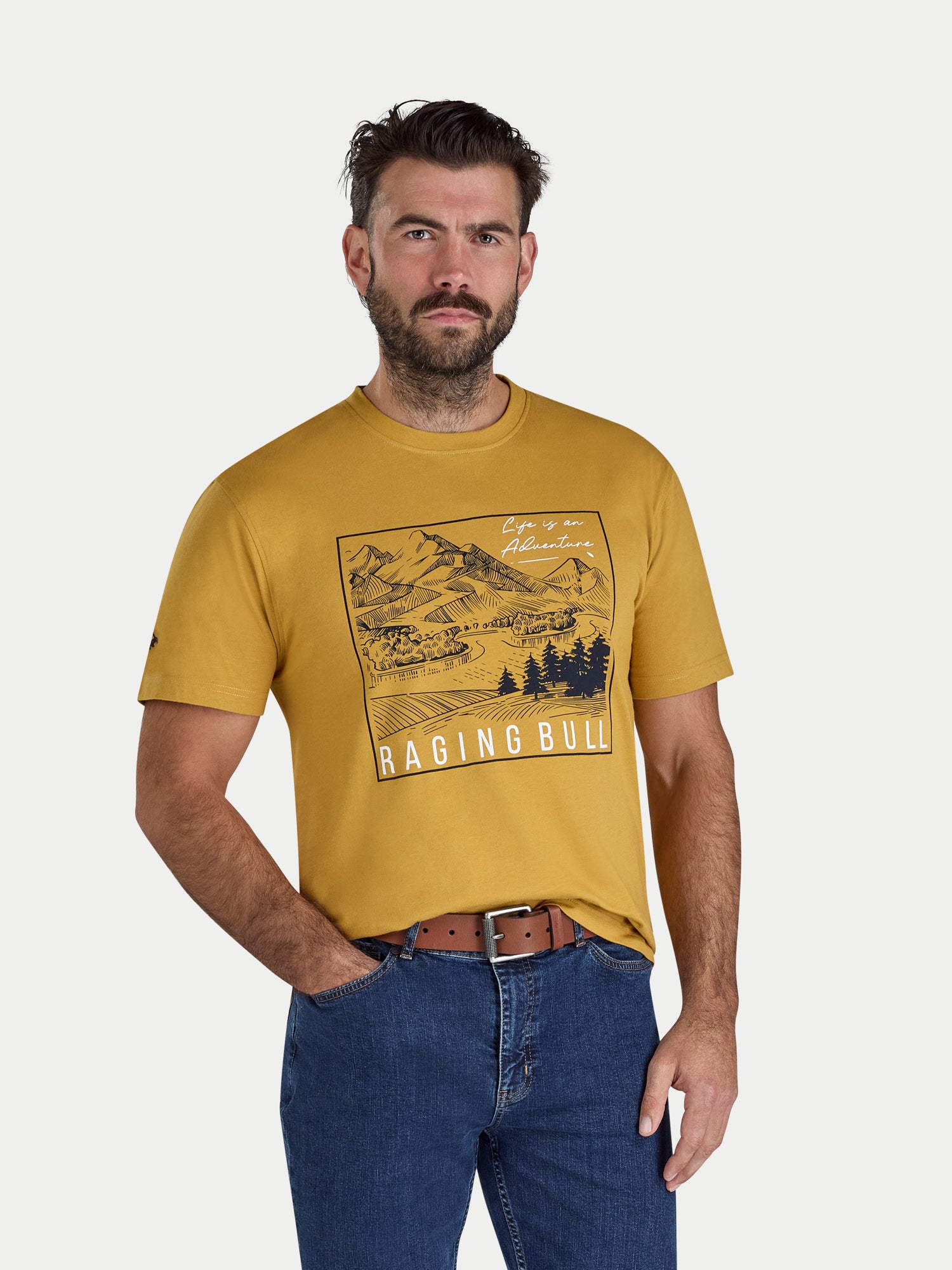 Man wearing a yellow t-shirt with a graphic design and text, standing against a plain background