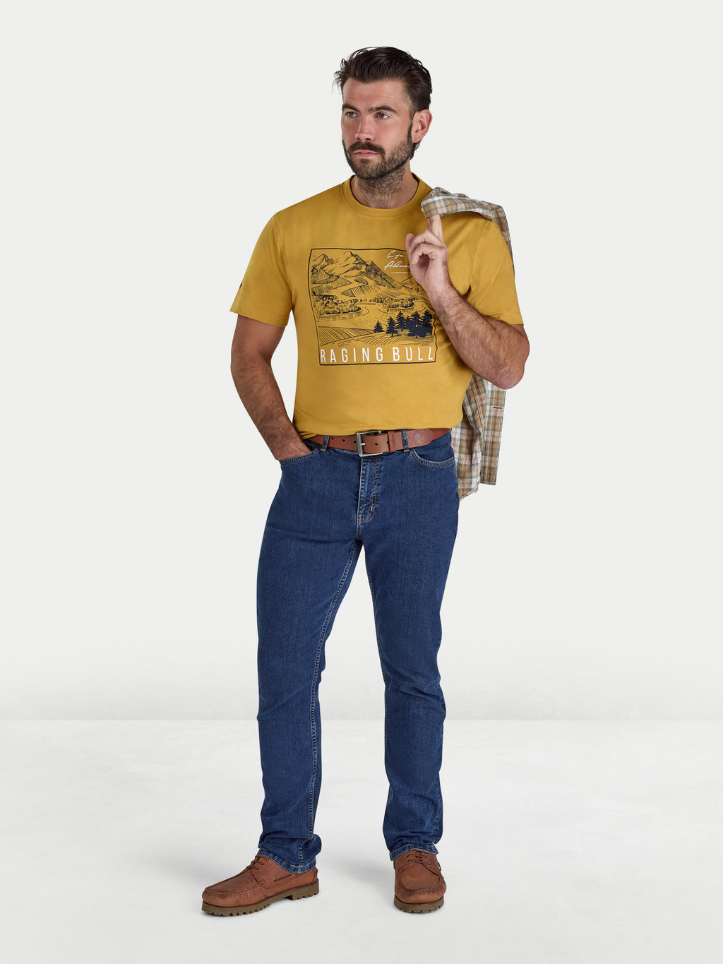 Man wearing a yellow t-shirt with graphic design, blue jeans, and brown boots on a white background
