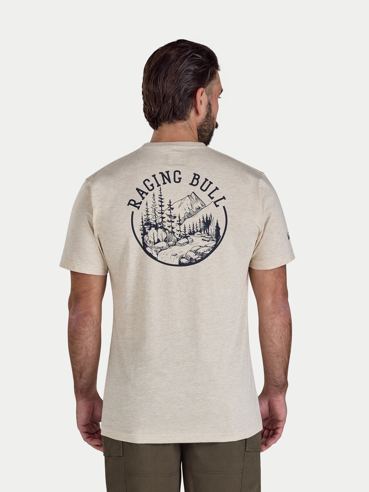 Man wearing a beige t-shirt with 'Raging Bull' logo on the back, standing against a white background