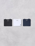 Three Raging Bull t-shirts in black, white, and navy on a gray background