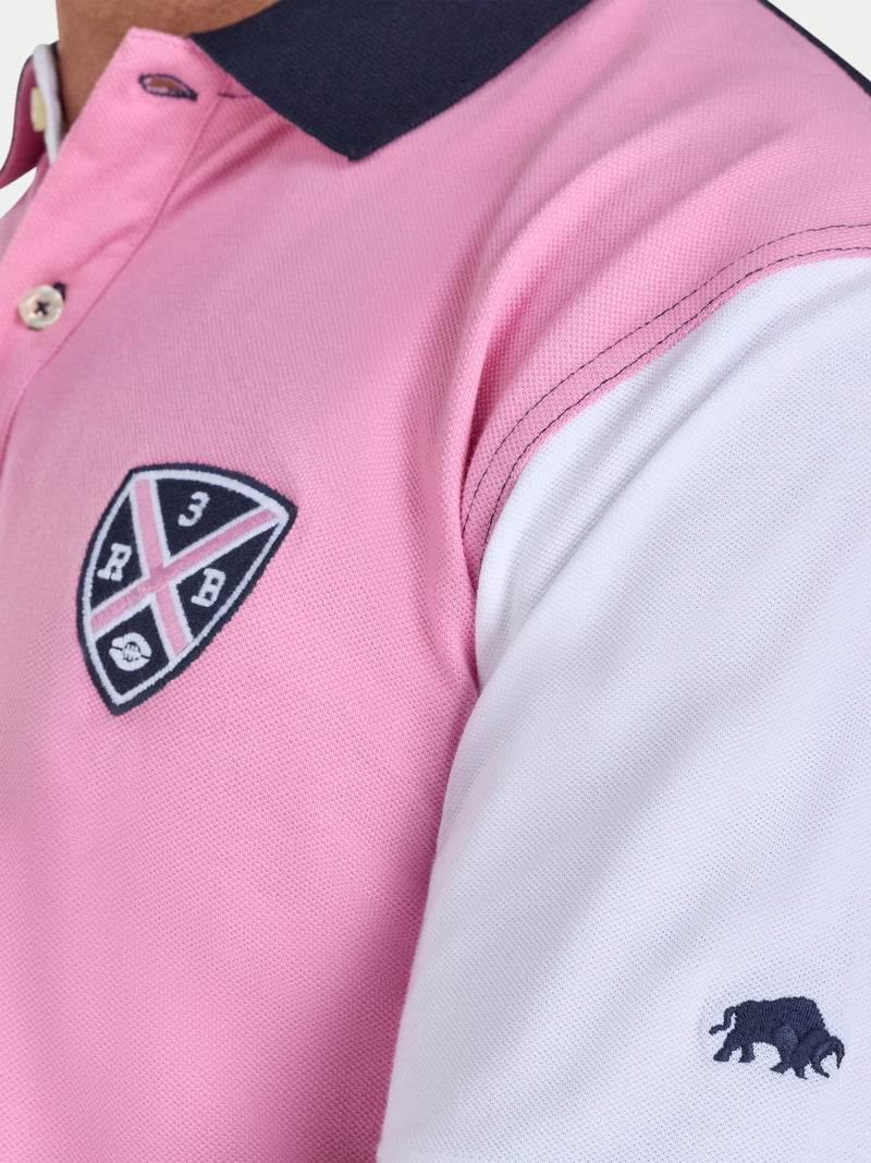 Close-up of a pink and white polo shirt with a logo on a white background