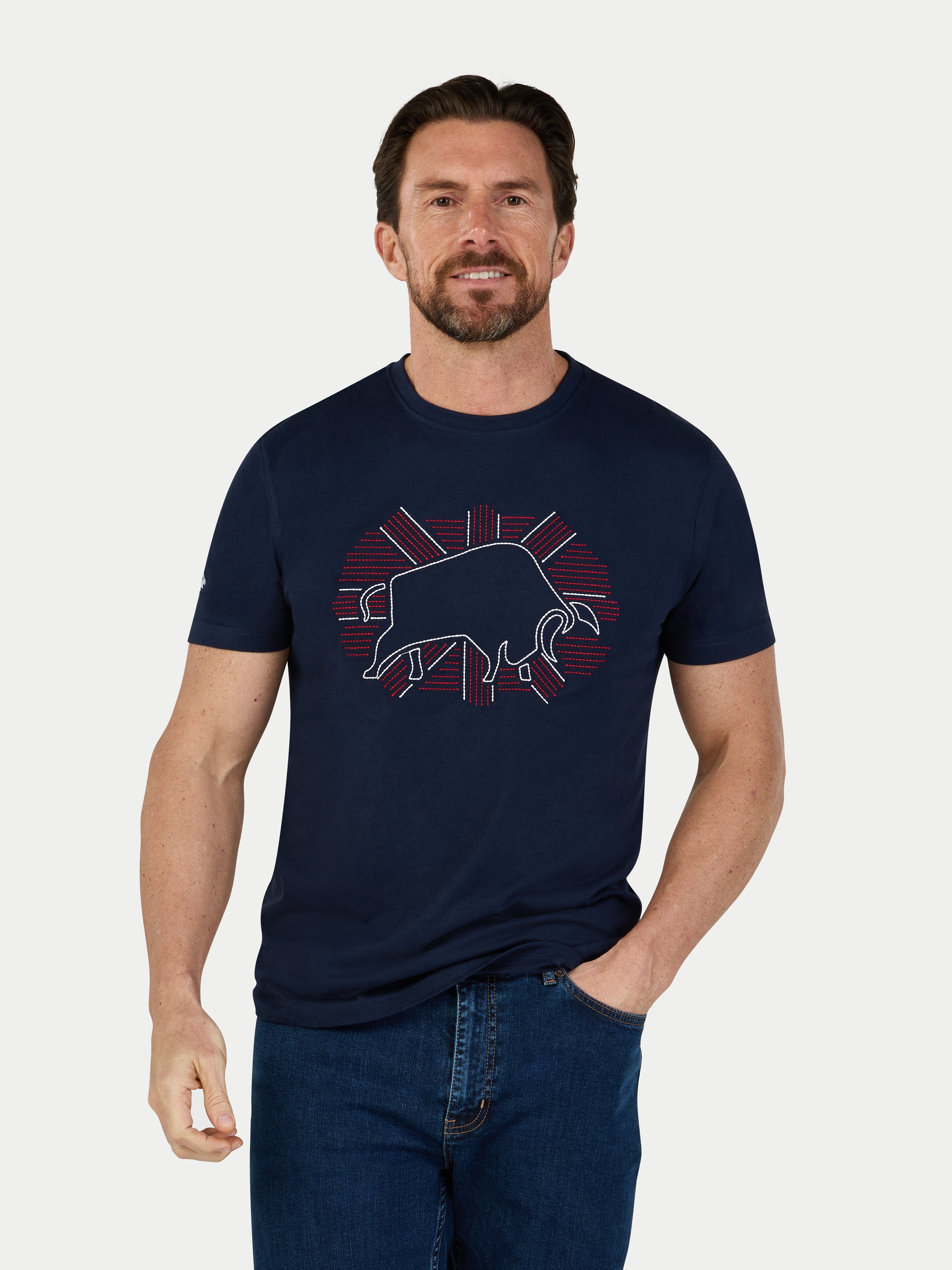 Man wearing a navy t-shirt with a graphic design on a white background