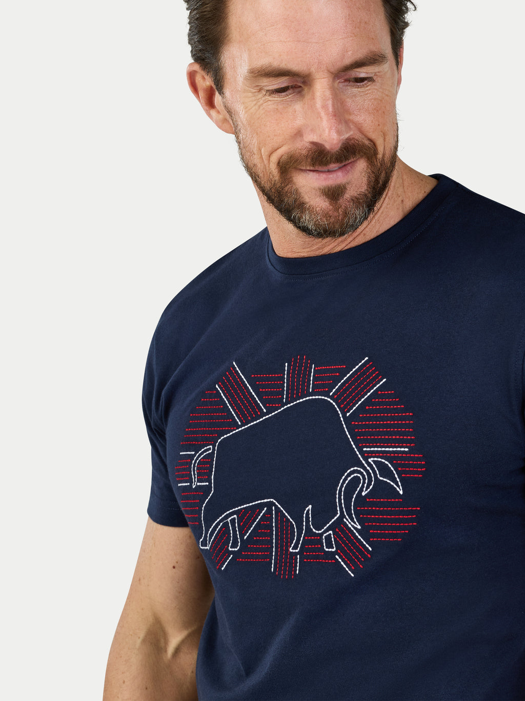 Man wearing a navy blue t-shirt with a bull logo design on a white background