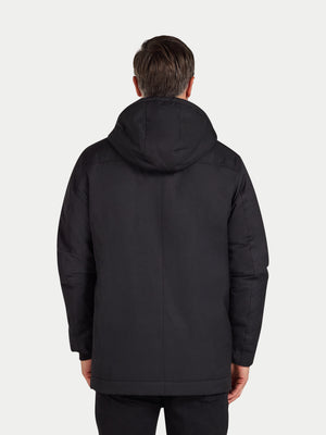 Person wearing a black jacket with a hood on a white background