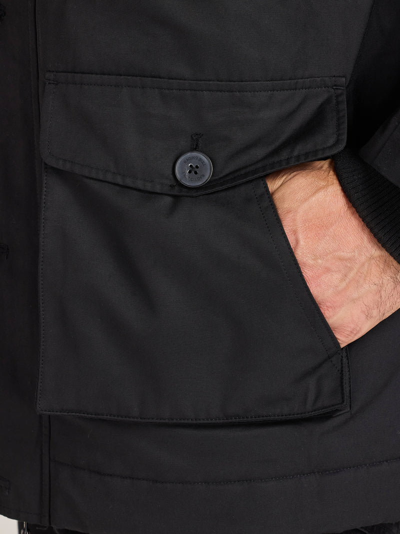 Close-up of a black jacket with a buttoned pocket