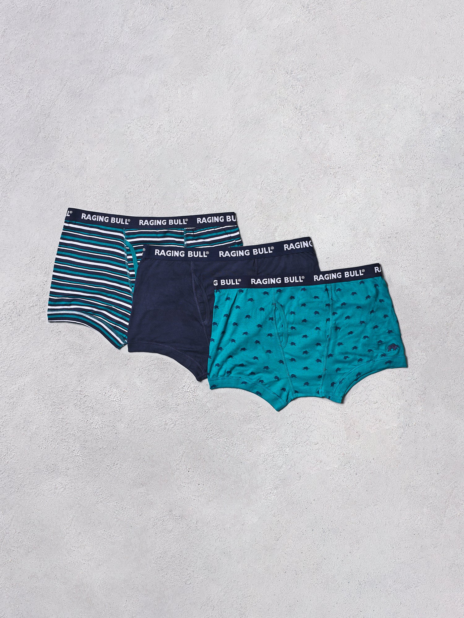 Three pairs of men's underwear from Raging Bull on a light gray background