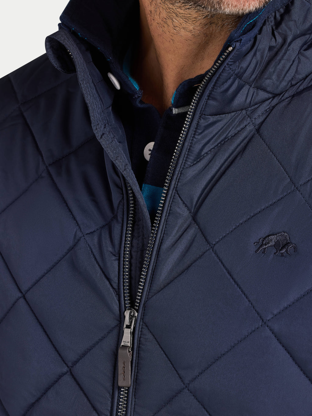 Navy quilted jacket with a brand logo on a light gray background