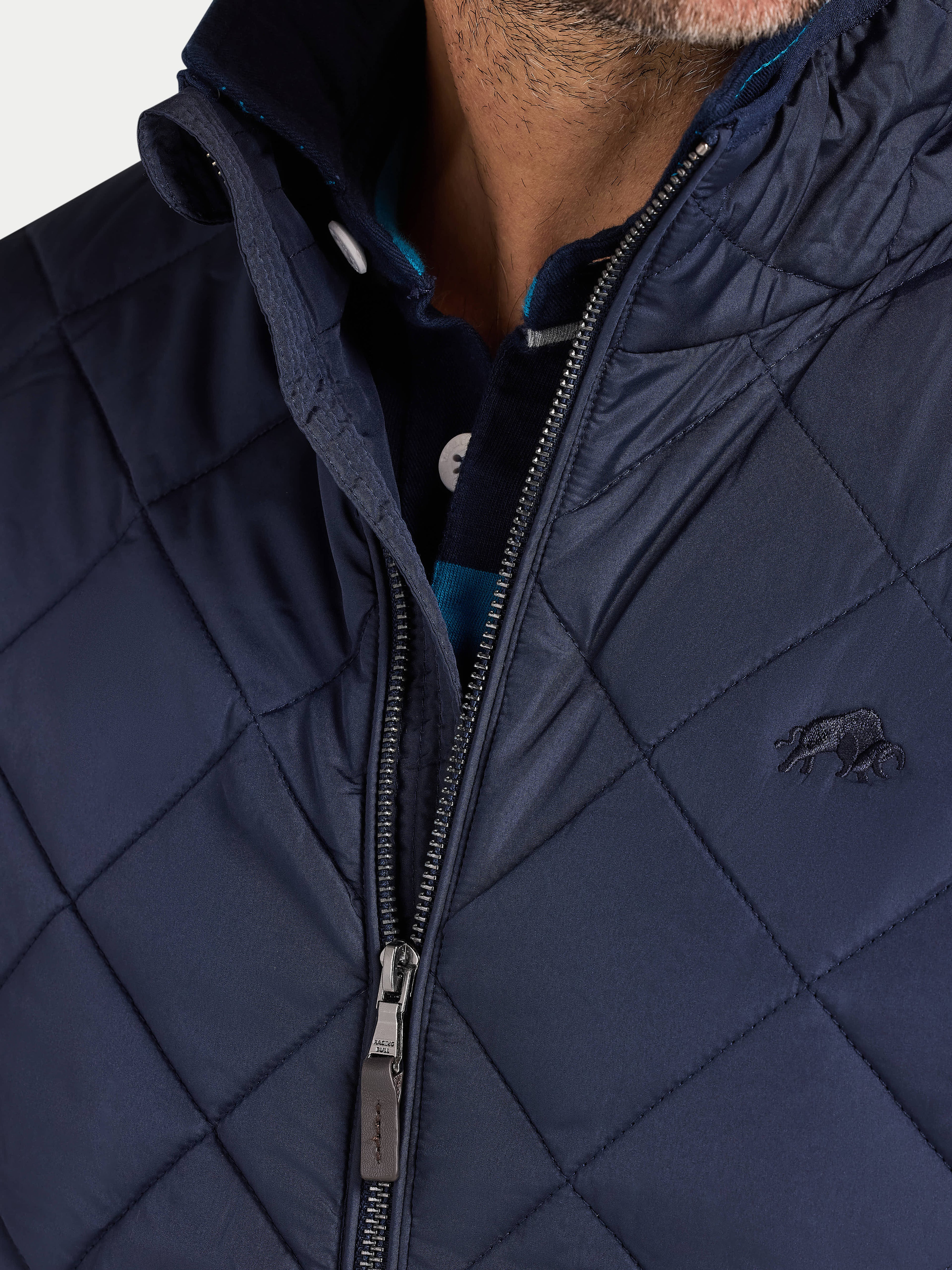 Navy quilted jacket with a brand logo on a light gray background