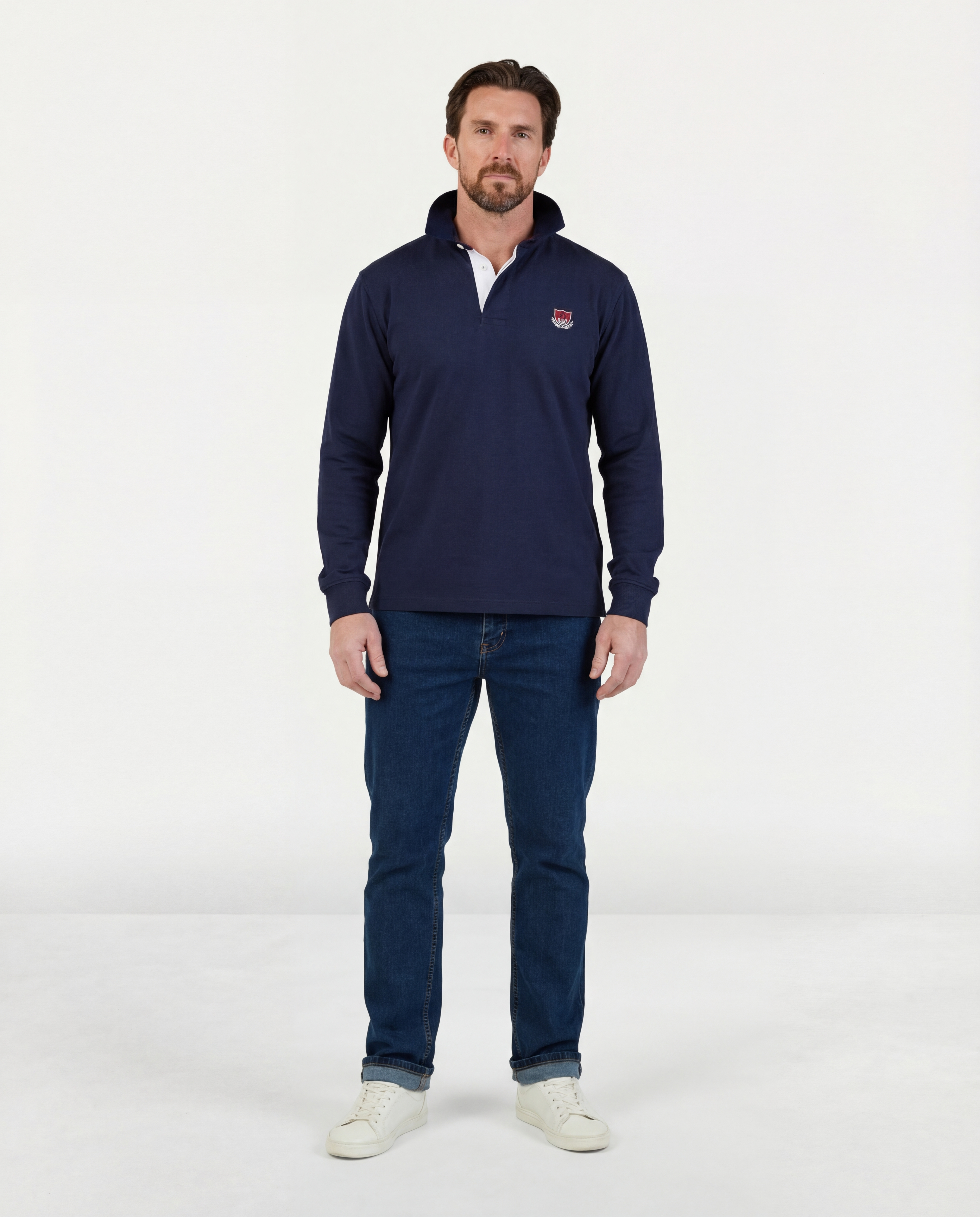 Man wearing a navy long-sleeve shirt and jeans on a white background