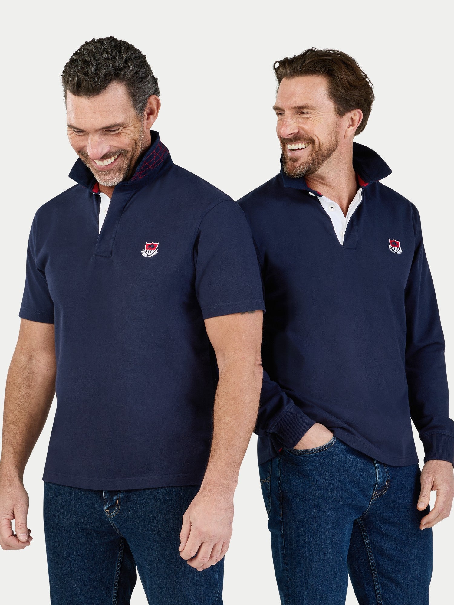 Two men wearing navy blue pullovers with a logo on a white background