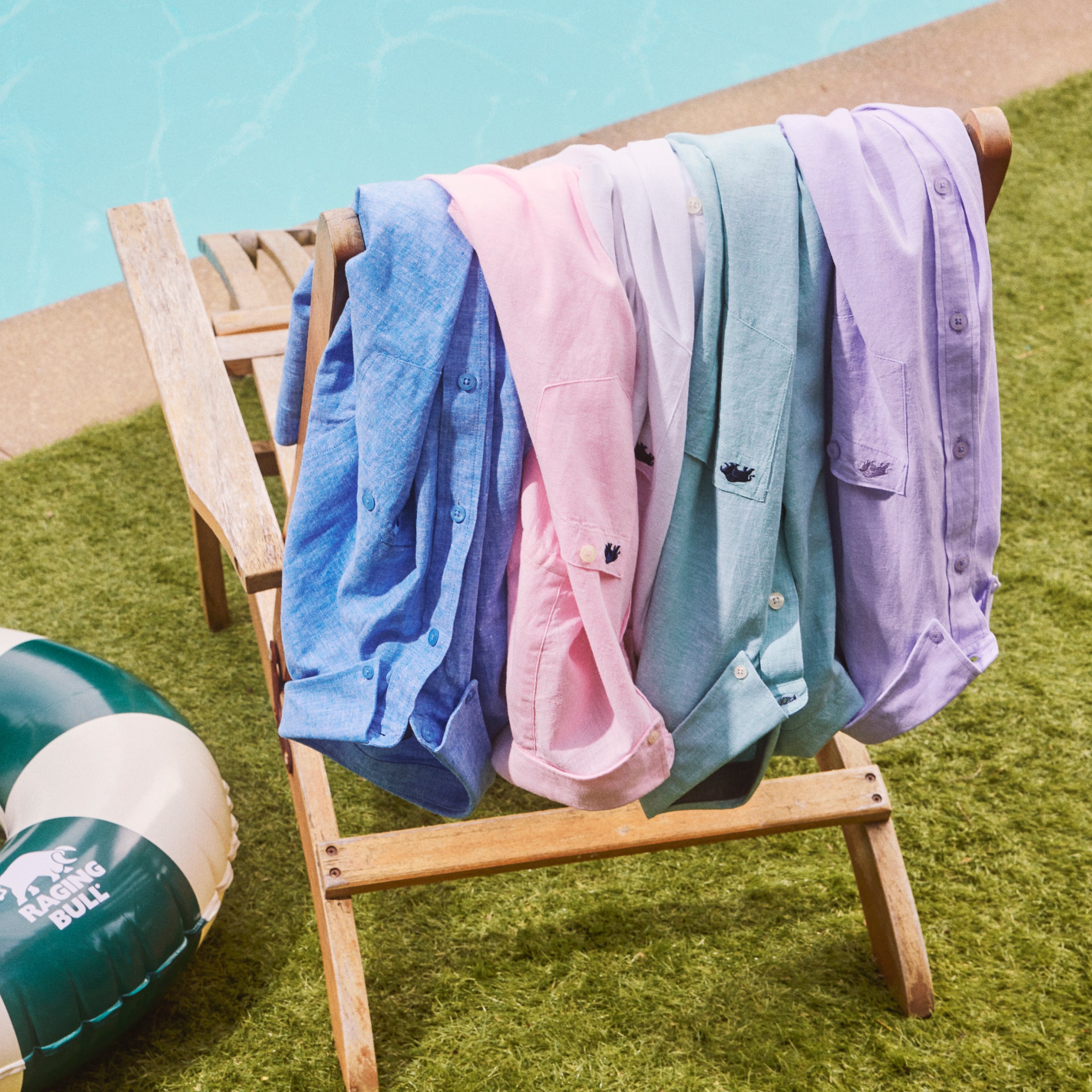 Raging Bull linen shirts on a sunbed next to a pool.
