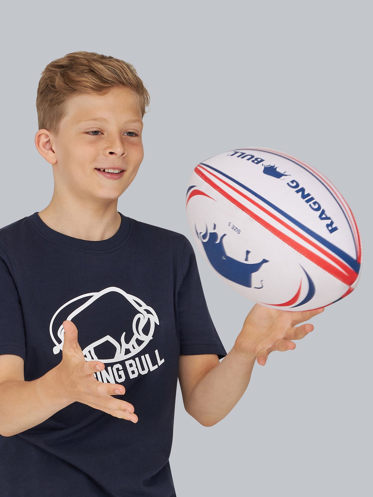 A boy throwing a Raging Bull rugby ball. 