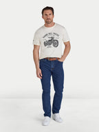 Man wearing a white t-shirt with a graphic design and blue jeans on a white background