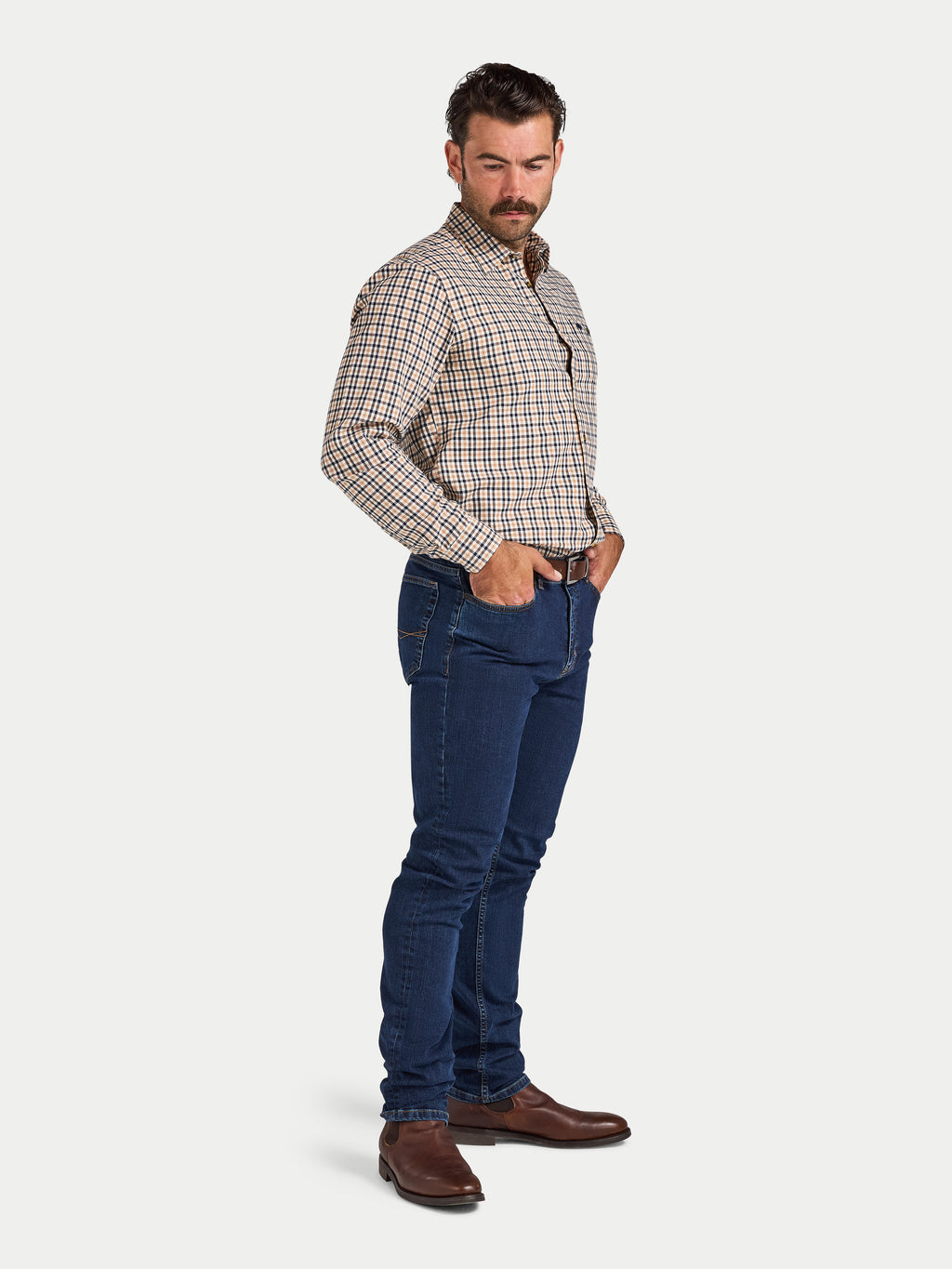Man wearing a checkered shirt and blue jeans on a white background