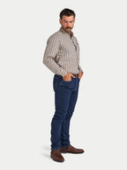 Man wearing a checkered shirt and blue jeans on a white background