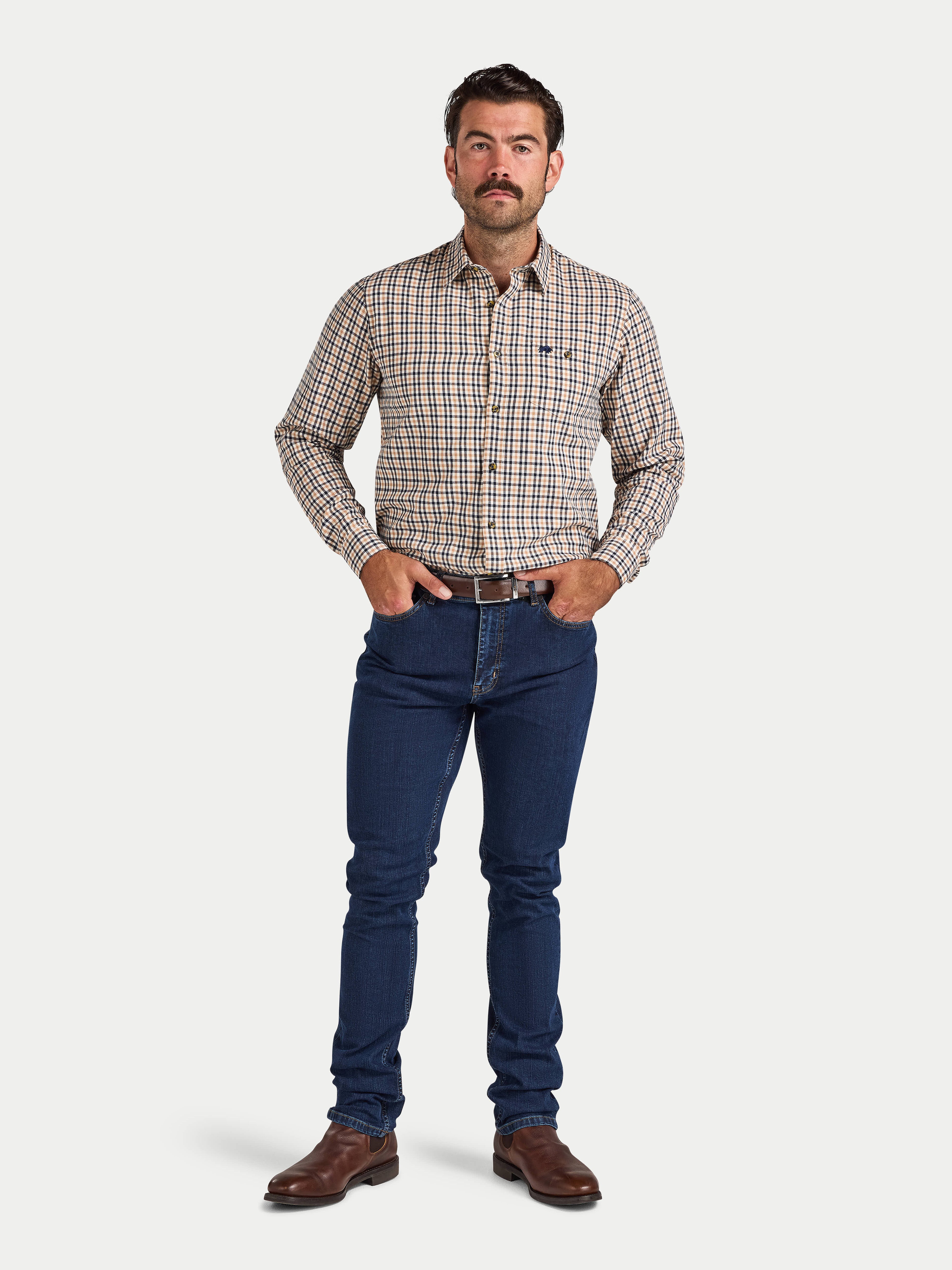 Man wearing a checkered shirt and blue jeans on a white background