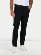 Person wearing black jeans and white sneakers on a white background