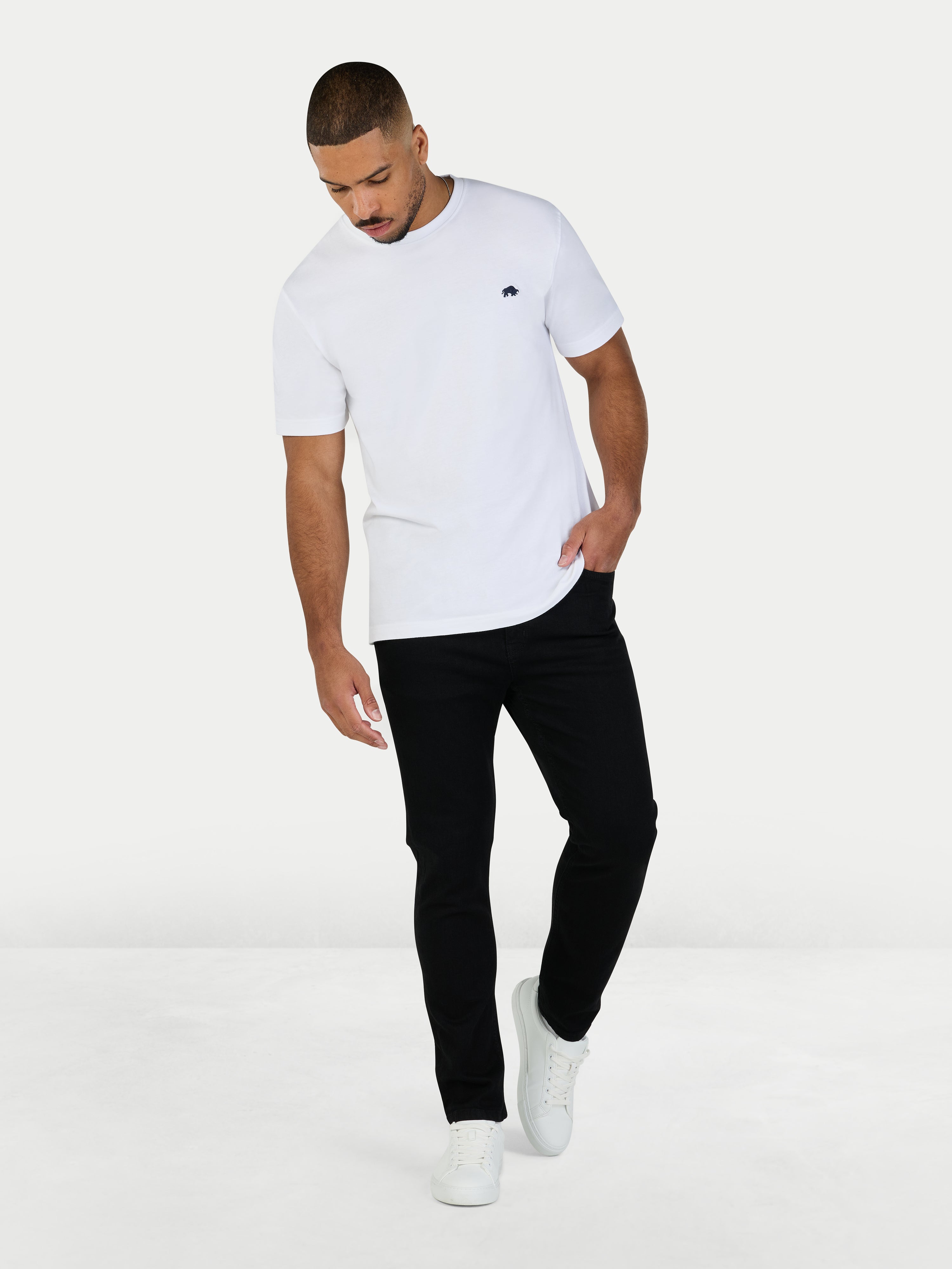 Man wearing a white t-shirt and black pants on a white background