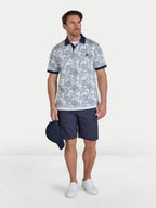 Man wearing a patterned polo shirt and navy shorts with a white background