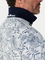 Close-up of a person wearing a jacket with a leaf pattern and a visible brand logo.