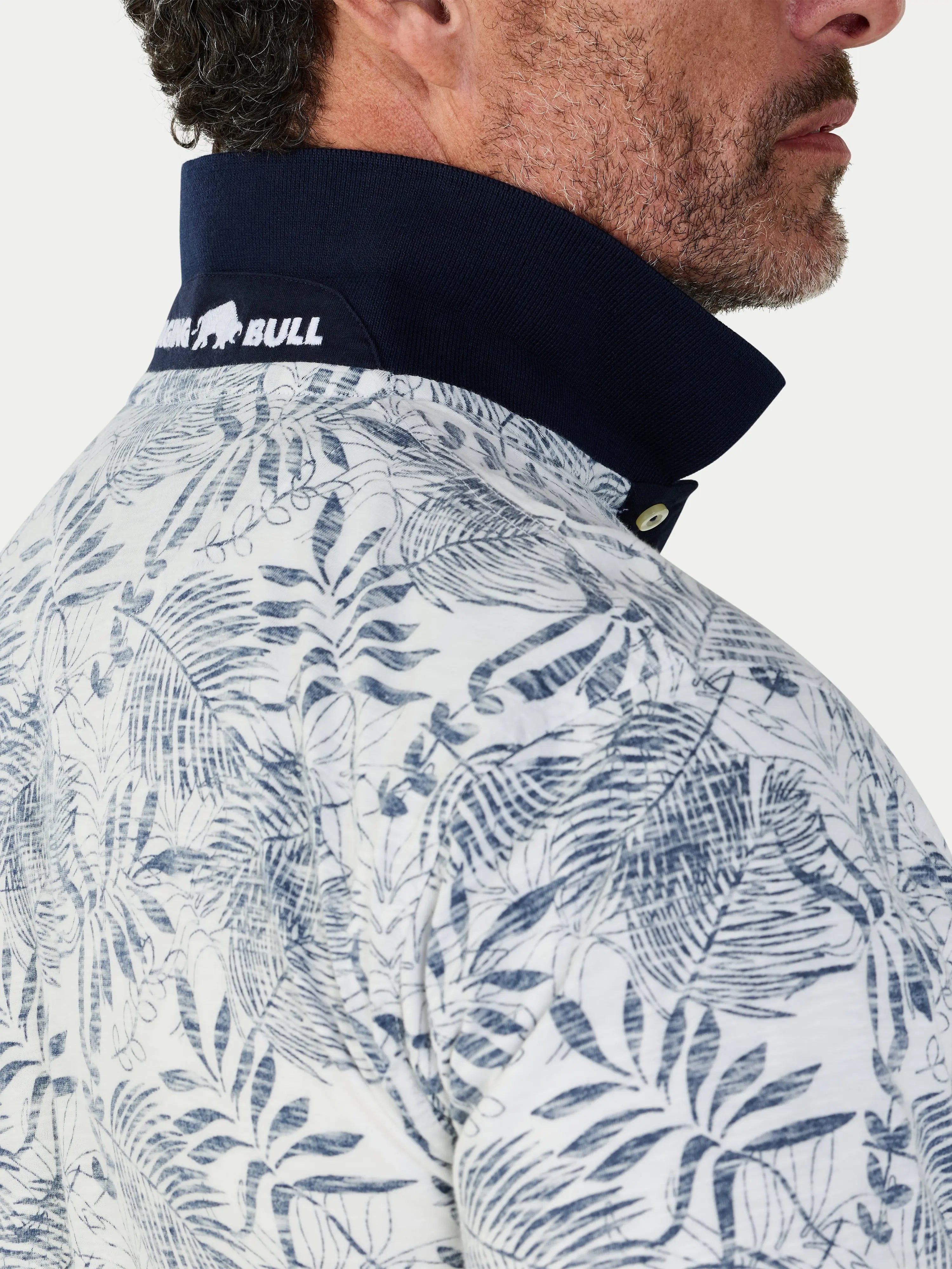 Close-up of a person wearing a jacket with a leaf pattern and a visible brand logo.