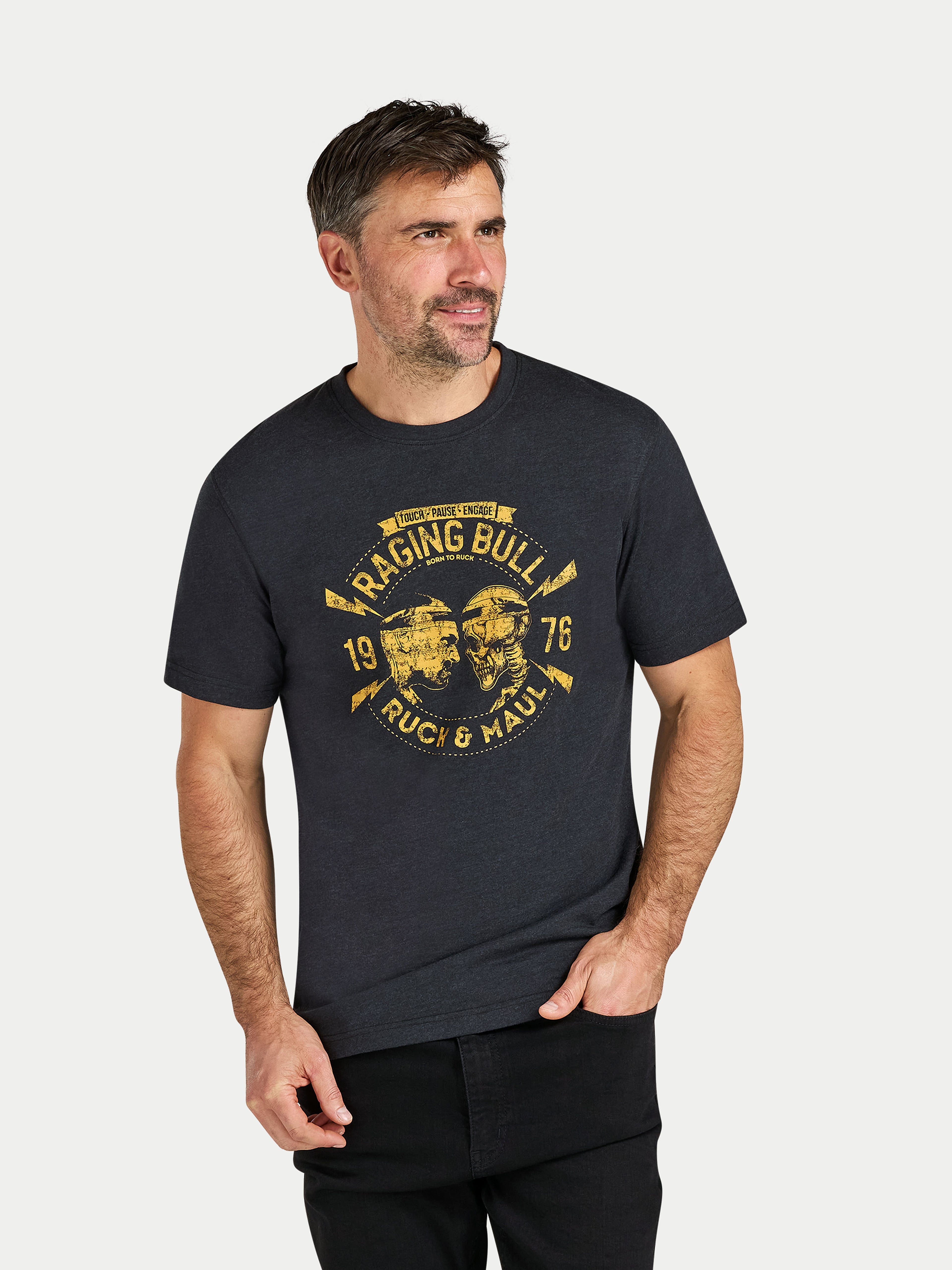 Man wearing a black t-shirt with yellow graphic design on a light gray background