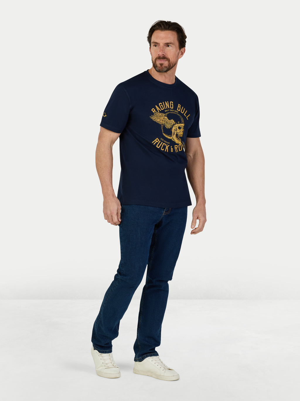 Man wearing a navy blue t-shirt with a logo and text, standing against a white background