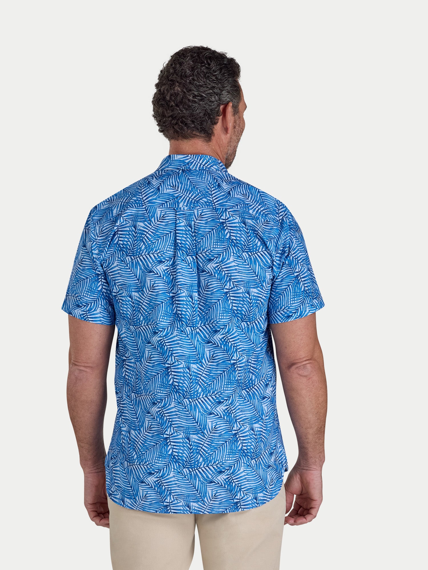 Man wearing a blue patterned shirt on a white background