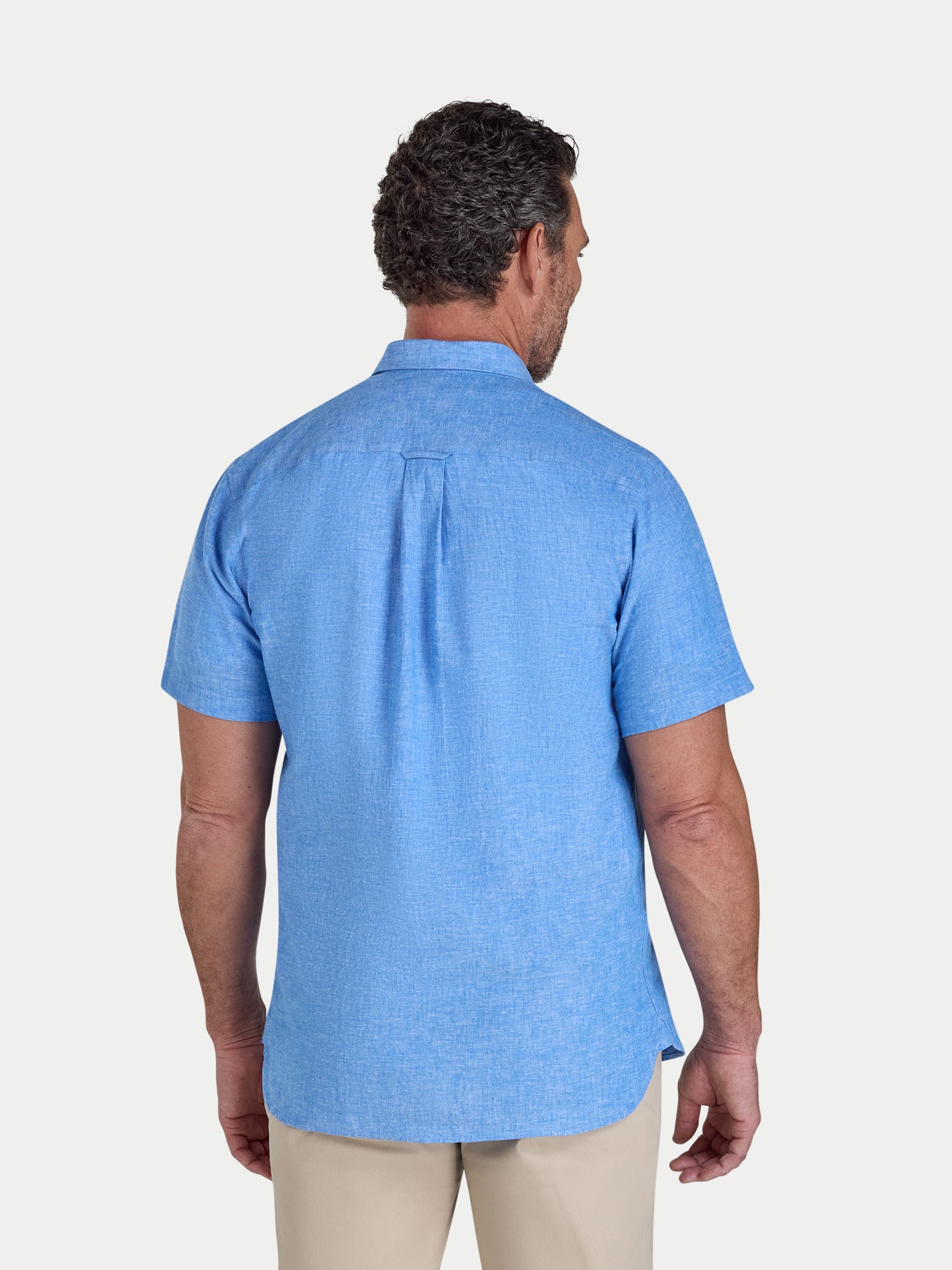 Man wearing a blue short-sleeve shirt on a white background