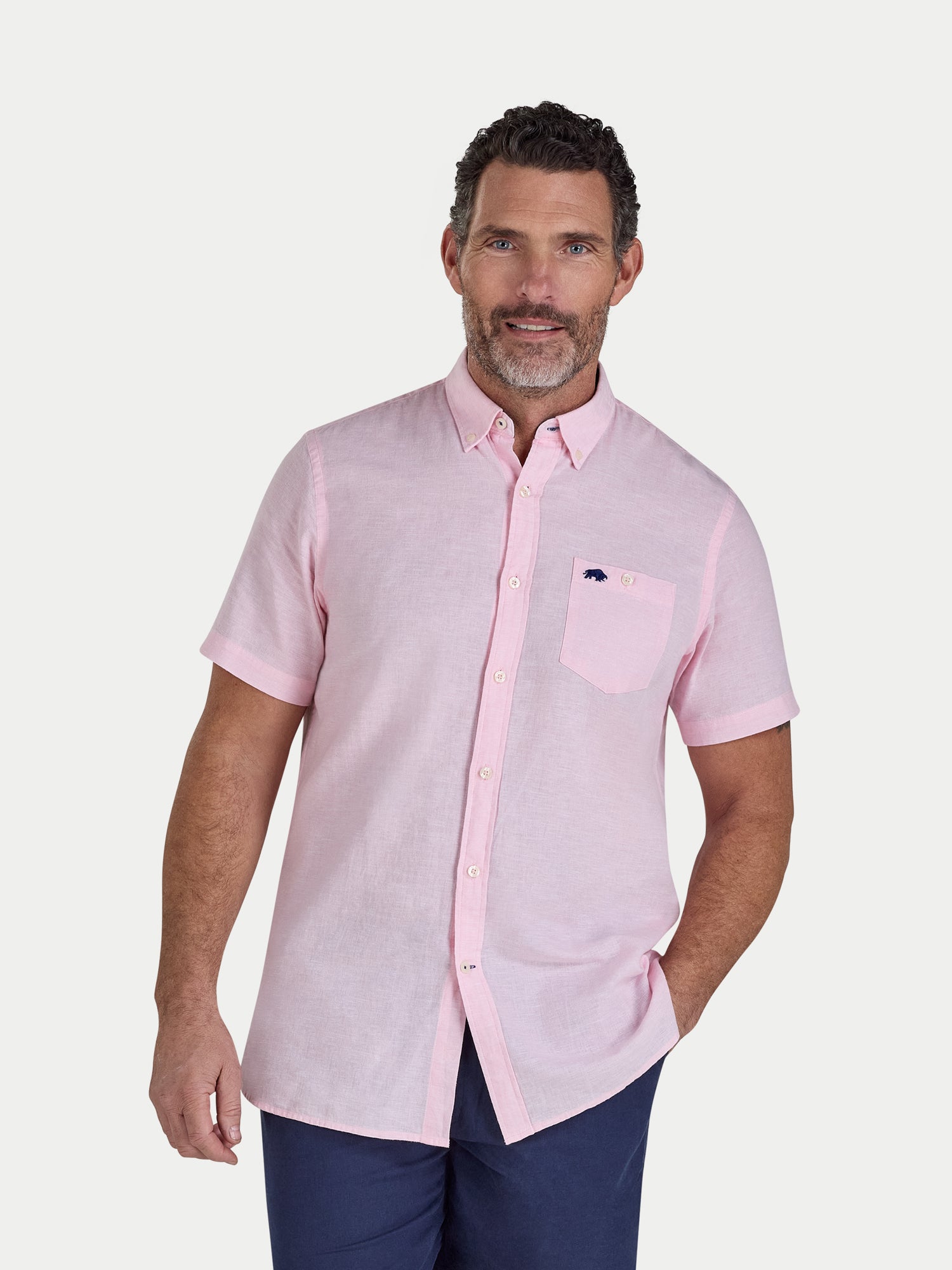 Man wearing a pink short-sleeve shirt with a white background