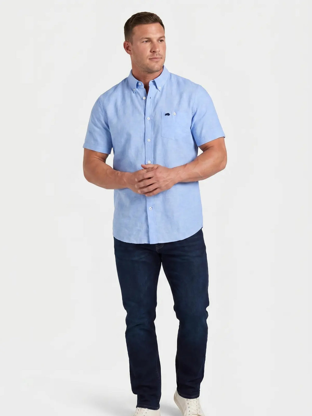 Man wearing Raging Bull short sleeve classic linen shirt in sky blue and regular fit jeans in denim, front. 