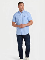 Man wearing Raging Bull short sleeve classic linen shirt in sky blue and regular fit jeans in denim, front. 